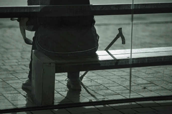 Person with cane sitting on a bench outdoors